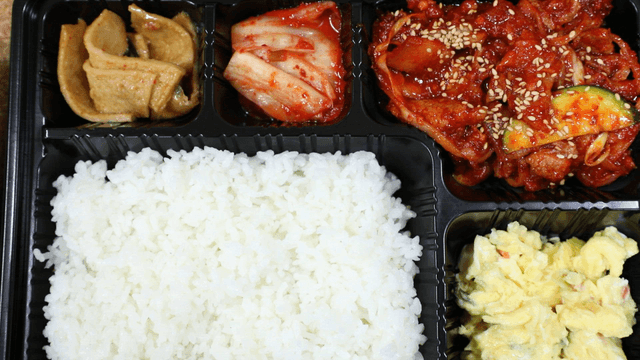 A Korean lunchbox with rice and side dishes