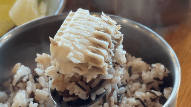 Spoonful of seaweed rice with glossy cutlassfish meat