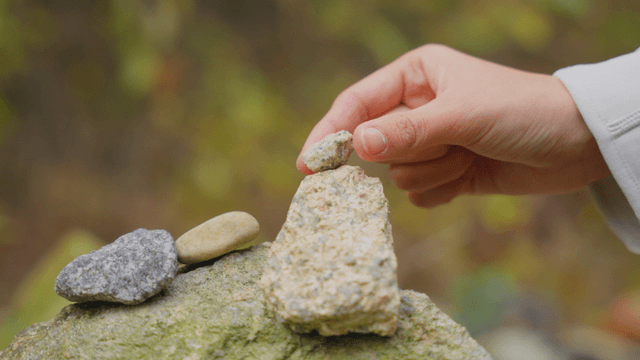 Hand stacking stones in nature