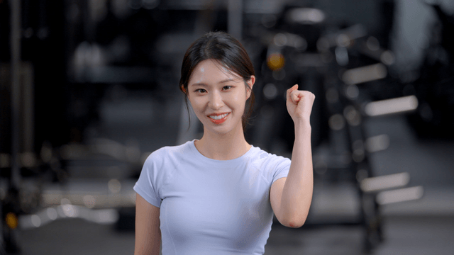Young woman cheering with clenched fists at gym