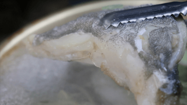 Cod soup boiling in pot with vegetables