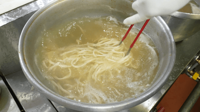 Noodles being cooked in a large pot