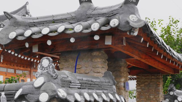 Rain falling on a traditional hanok with stone walls