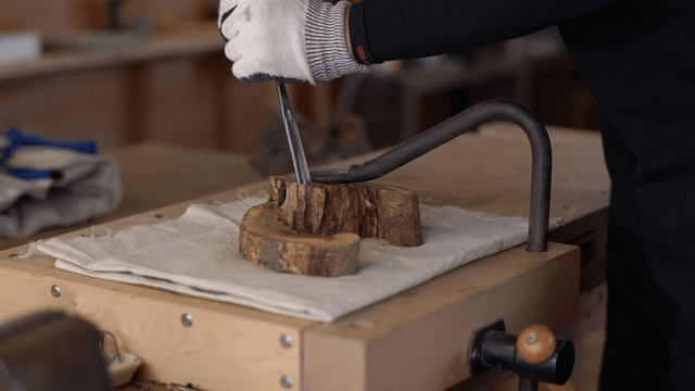 Woodcraft artisan carving wood with a chisel at workbench