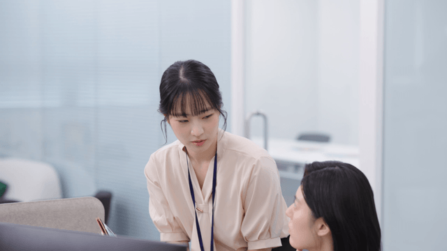 Two colleagues discussing work at a desk