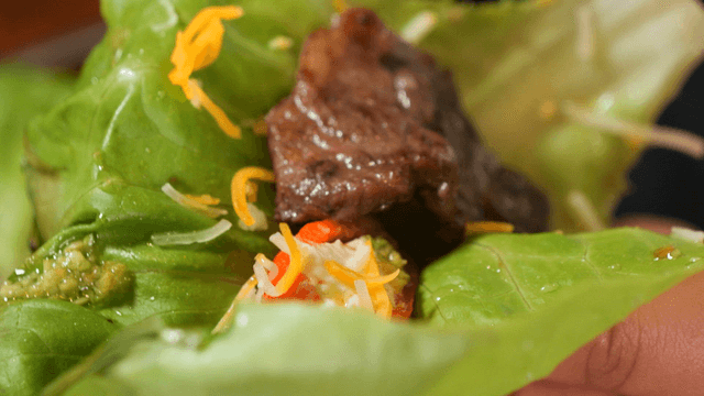 Preparing a lettuce wrap with meat and vegetables