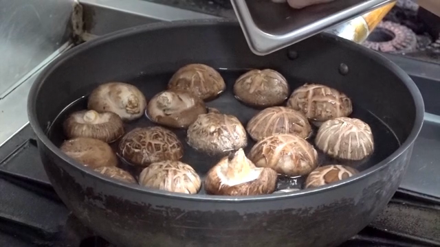 Mushrooms being added to a pot of water