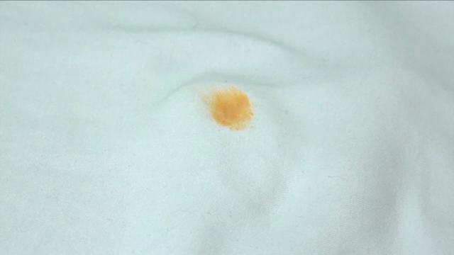 Finger rubbing a stain on a cloth