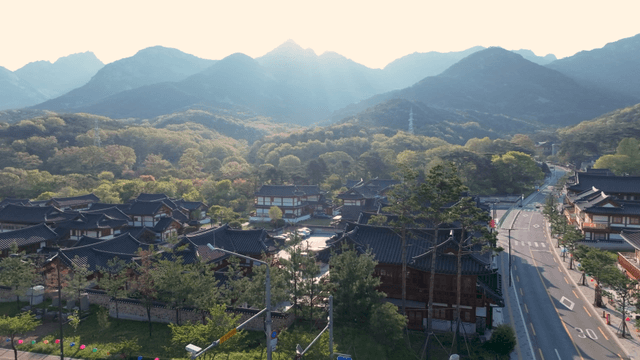 Hanok village surrounded by mountains under dazzling sun