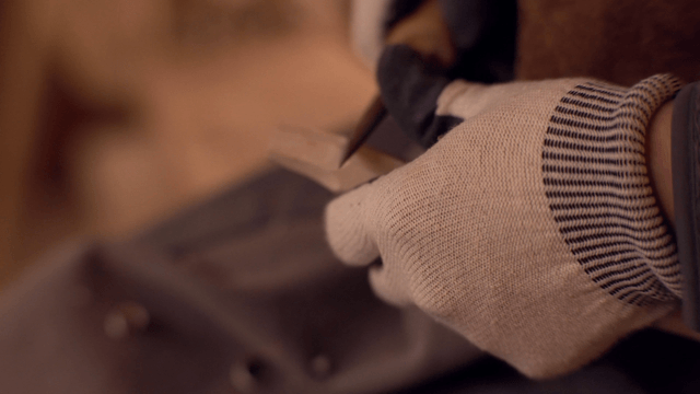 Hands carving wood with precision