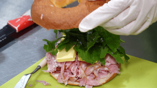 Sandwich topped with arugula and covered with bread