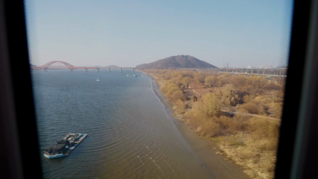 A river with a bridge and distant mountain
