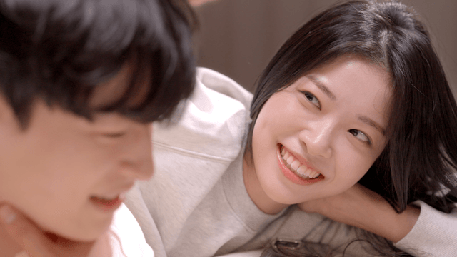 Couple resting on bed with gentle smiles