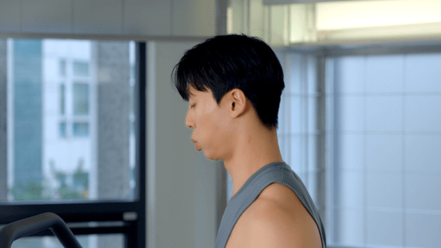 Young man jogging on a treadmill in gym
