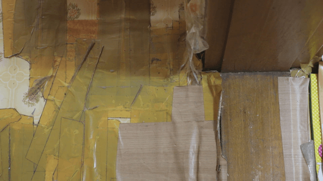 Corner of a room with taped wallpaper