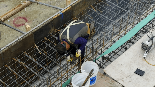 Construction worker welding rebar