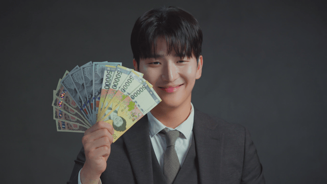 Man smiling at the bills in his hand