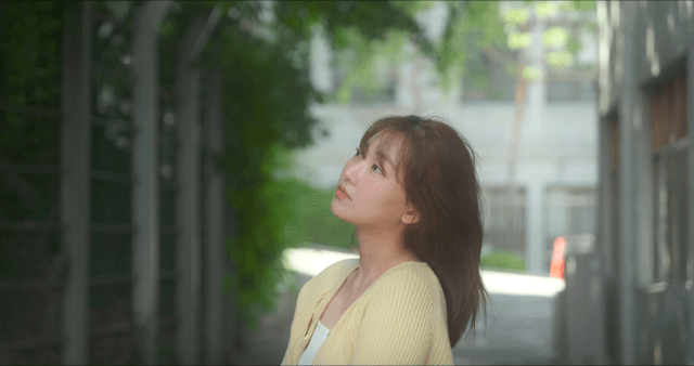 Woman looking up in a sunlit alley