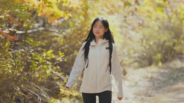 Young woman happily descending autumn trail