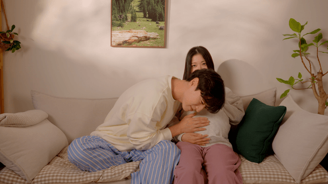 Husband listening to pregnant wife's belly