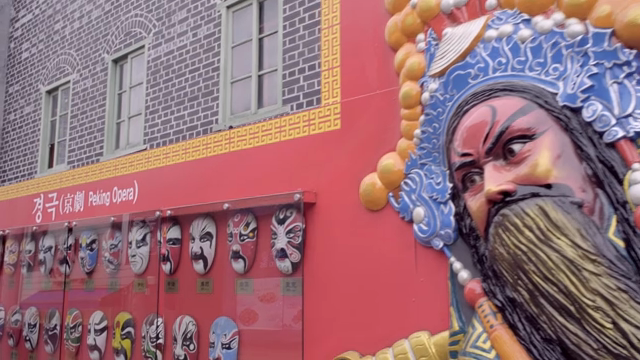 Peking opera masks displayed on a wall