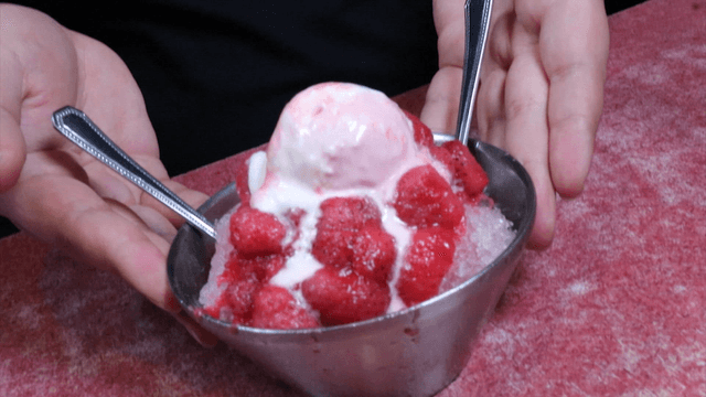 A bowl of strawberry shaved ice on a table