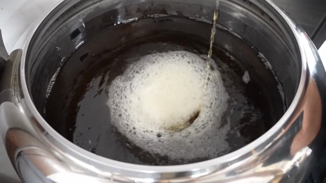 Pouring liquid into a large metal pot