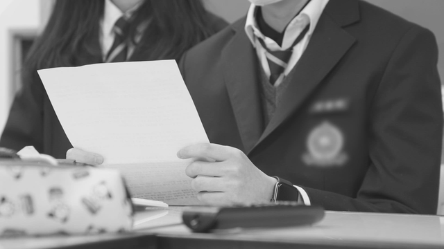 Students reading a document at a desk