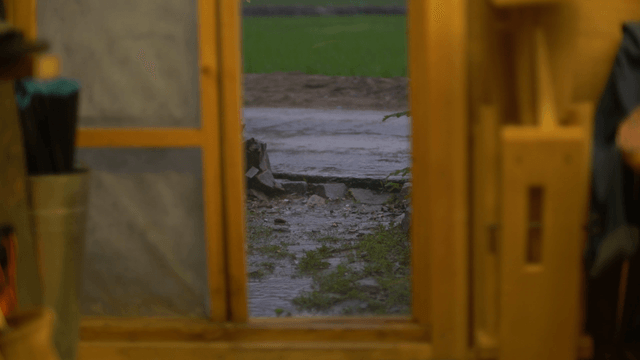 Rainy scenery beyond the wooden door of a workshop