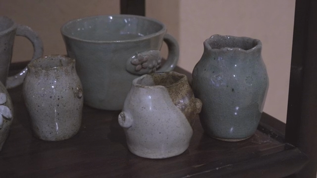 Handcrafted pottery on a wooden shelf