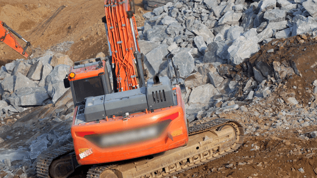 Excavator working on rocky terrain