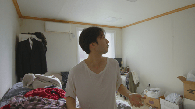 Young man in a messy room looking up