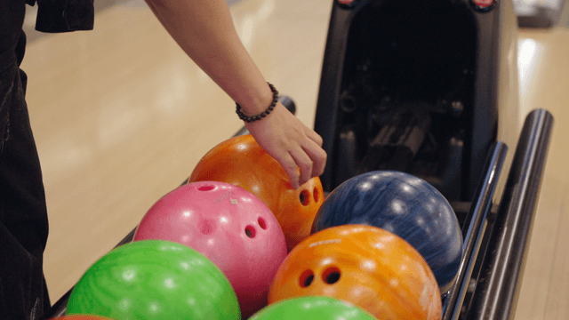 Selecting a bowling ball from the rack
