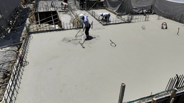 Workers smoothing concrete at a construction site