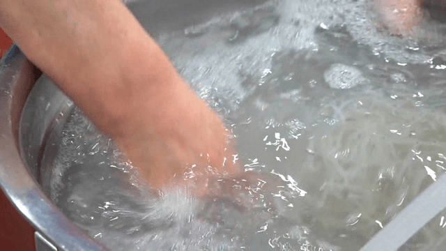 Chopsticks washing ice fish in basin of water