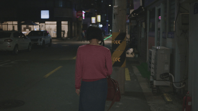 Frustrated woman walking alone on a city street at night