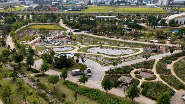 Park view with diverse trees flowerbeds and a pond walkway