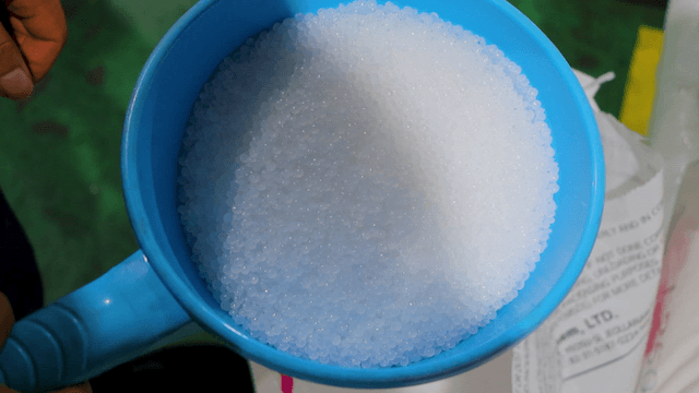 흰색 알갱이로 가득 찬 파란 바가지