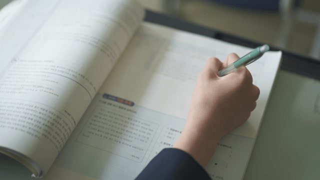 Student writing in a workbook