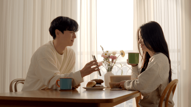 Couple taking photo of breakfast at dining table