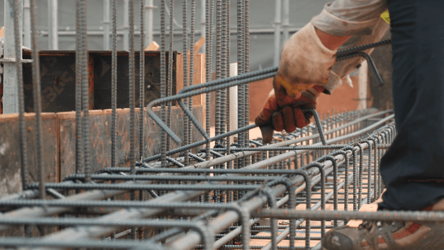 Worker assembling rebar at a construction site