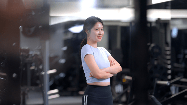 Side view of a smiling young woman at gym