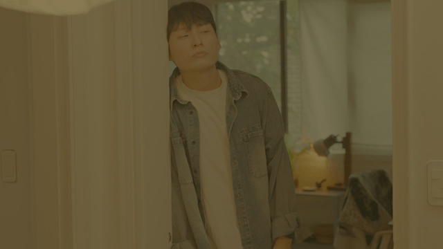 Man smiling while leaning on door frame