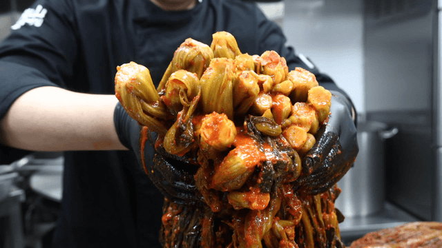 Chef holding gatgimchi with dripping broth