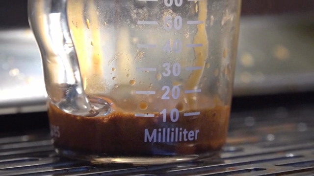 Espresso dripping into a shot glass