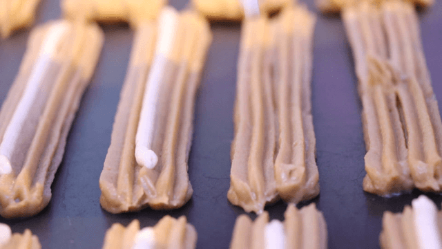 Piping cream onto brown dough