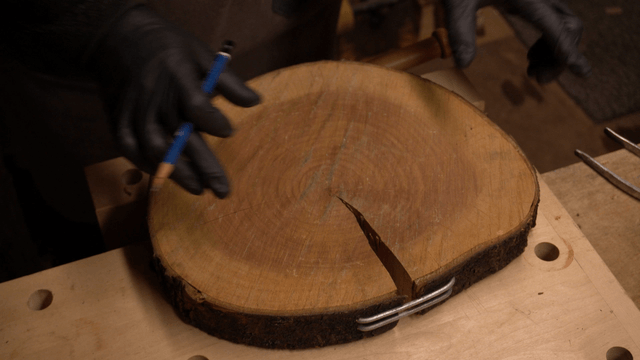 Artisan marking wooden board with pencil