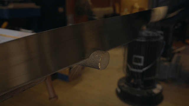 Large saw cutting wooden stick