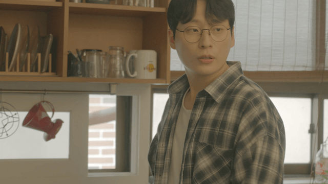 Man with glasses preparing something in kitchen