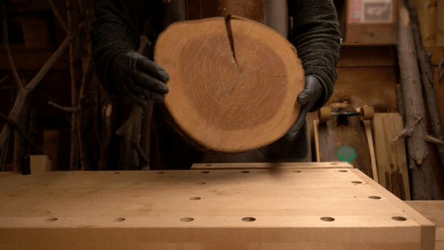 Craftsman holding a wooden board in workshop